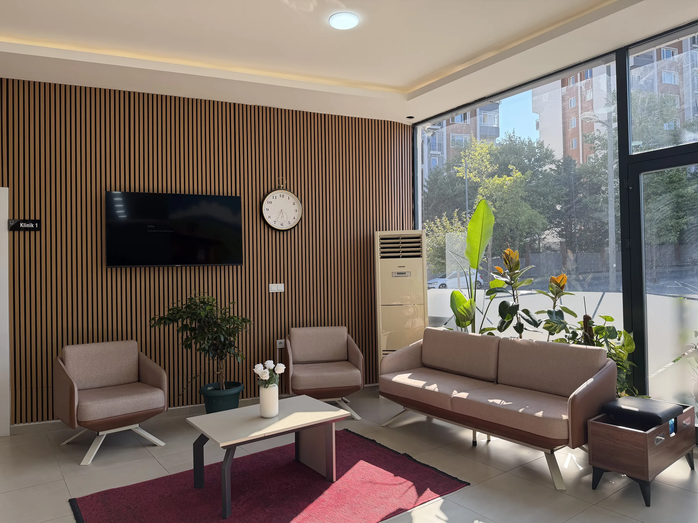 Bekleme alanı — bej koltuklar ve ahşap panel duvar